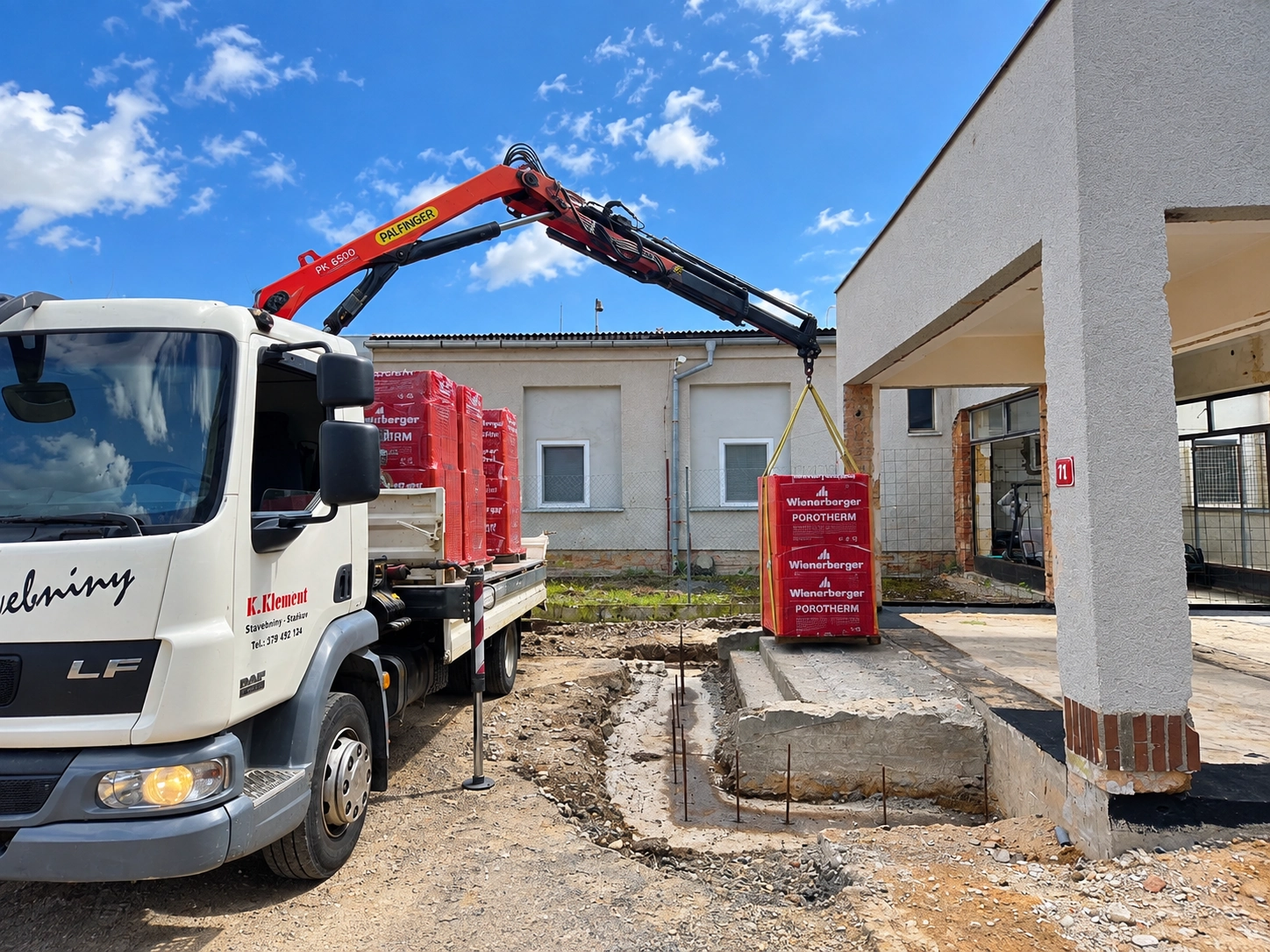 Dodávka Porotherm s hydraulickou rukou na stavbě